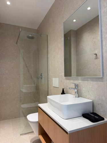a bathroom with a sink and a shower and a toilet at Soléa Himara Guesthouse in Himare