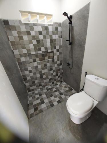 a bathroom with a toilet and a shower at Slab Krui Bungalows in Krui