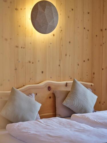 a bedroom with a bed with white sheets and pillows at Holz100 Kleinhaus in Attinghausen