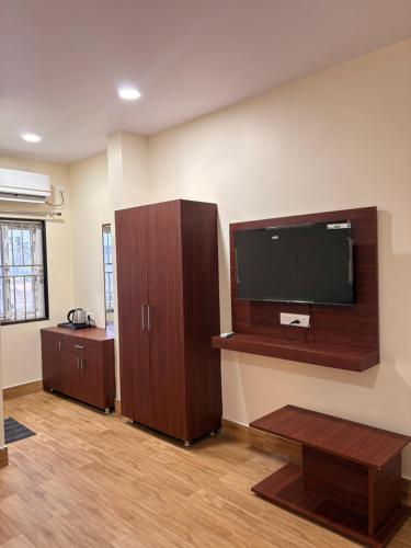 a living room with a flat screen tv on a wall at TSR Grand Hotel in Bhogāpuram