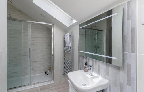 a white bathroom with a sink and a shower at Seagrass in Sandown
