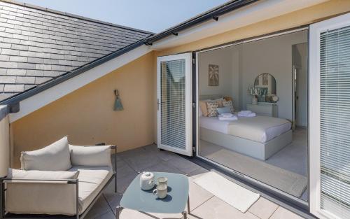 a balcony with a couch and a bed at Seagrass in Sandown