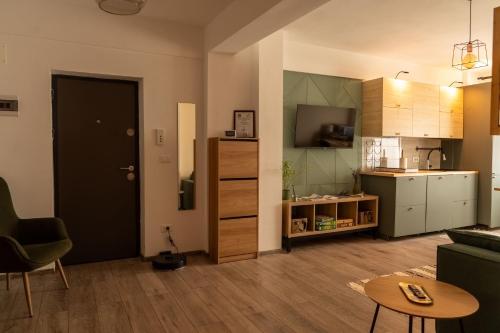 ein Zimmer mit Küche und ein Wohnzimmer mit Tisch in der Unterkunft CITADEL VIEW in Târgu Neamţ