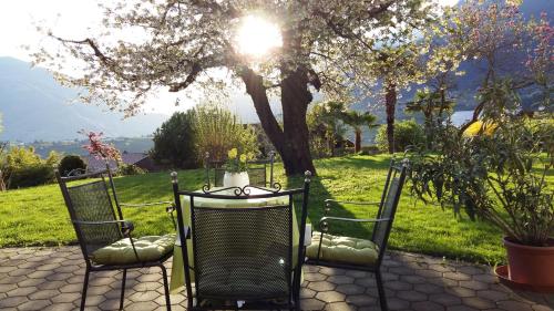a table and two chairs with the sun in a field at Hotel Garni Katnau in Schenna