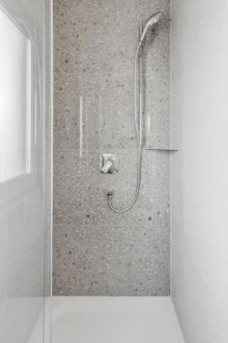 a shower with a shower head in a bathroom at Studio Apartment Dietzenbach in Dietzenbach