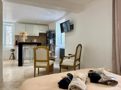 a room with a bed and chairs and a kitchen at Chaleureux T1 avec Balcon in Vals-les-Bains