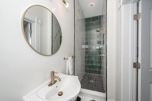 a bathroom with a shower and a sink and a mirror at Historical John H Dickman House in Covington