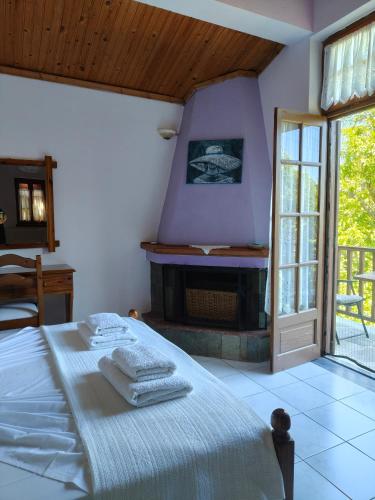 a bedroom with a bed with towels on it at Filoxenia in Tsagarada