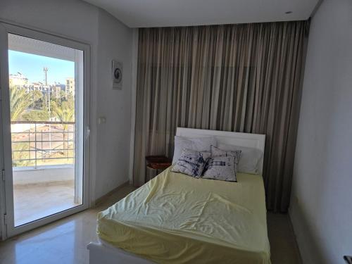 a bedroom with a bed and a large window at luxurious two bedroom appartement in Hiboun