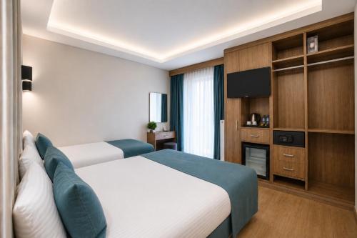 a hotel room with two beds and a tv at Hotel Black Tulip in Istanbul