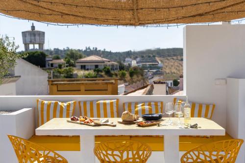 a table with chairs and a plate of food on a balcony at DamnView Montargil Alentejo in Montargil