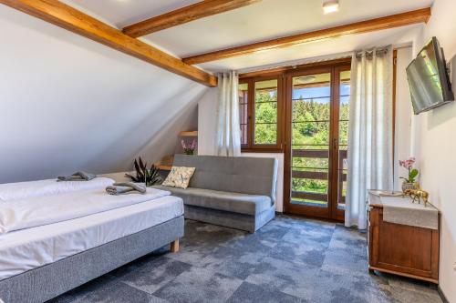 ein Schlafzimmer mit einem Bett und einer Couch in der Unterkunft Pod Orlicą in Duszniki-Zdrój