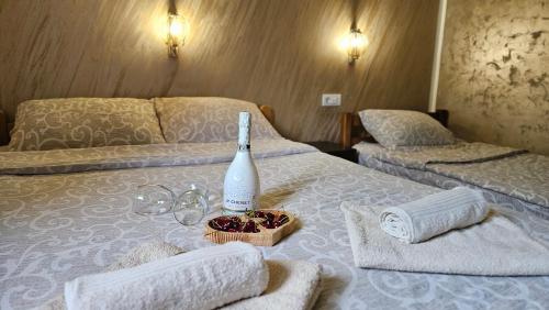 a room with two beds with towels and a bottle of wine at Studio Eli sa dvorištem in Veliko Gradište