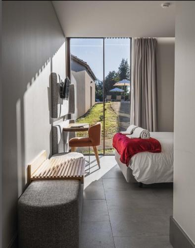 a bedroom with a bed and a desk and a tv at Villã - Casas de Campo in Paredes
