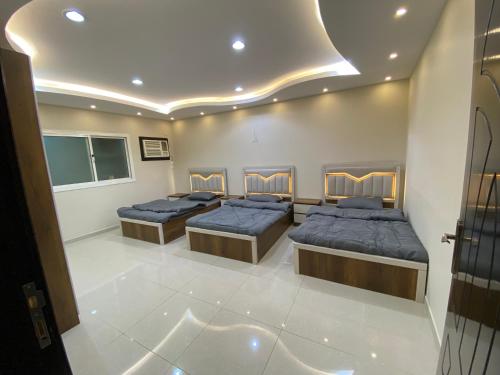 a room with four beds in a room at كازا in Taif