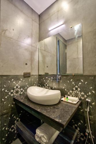 a bathroom with a sink and a mirror at The Goa Courtyard by Forever stays in Arpora