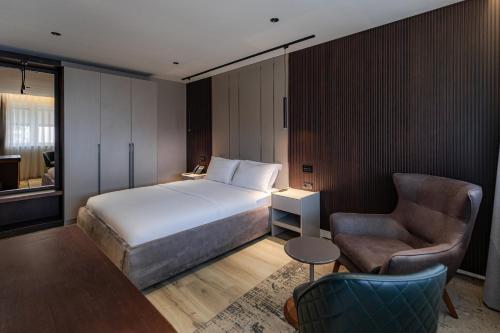 ein Hotelzimmer mit einem Bett und einem Stuhl in der Unterkunft Emery Hotel in Pristina