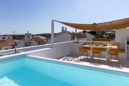 a villa with a swimming pool and a balcony with a table and chairs at DamnView Montargil Alentejo in Montargil