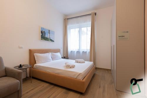 a bedroom with a bed with two towels on it at Collegno Cozy Apartments in Turin