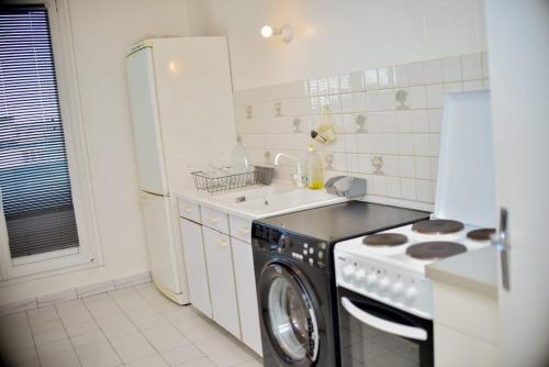 a kitchen with a stove and a washing machine at super apparemment pour vos vacances in Neuilly-sur-Marne