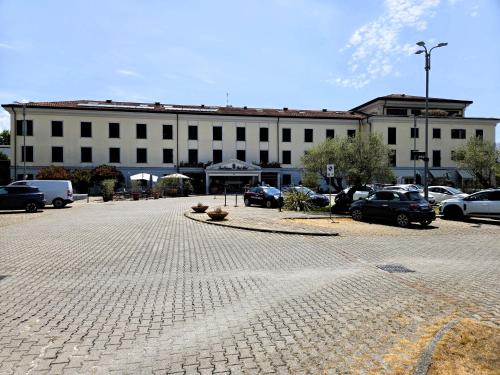 a large white building with cars parked in a parking lot at Santa Caterina Park Hotel in Sarzana