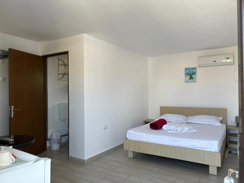 a bedroom with a bed with white sheets and a bathroom at Vila Elna in 2 Mai