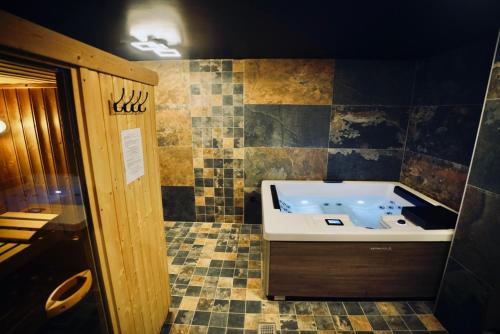 a bathroom with a tub with a tiled floor at Moontain Lodge in Oz