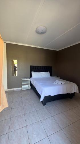 a bedroom with a large white bed and a tiled floor at Rundu Rainbow Guesthouse in Rundu