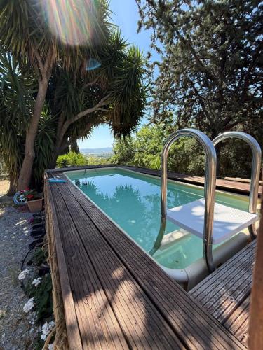 a wooden bench next to a small swimming pool at Podere Baloo Country Holiday Home in Suvereto
