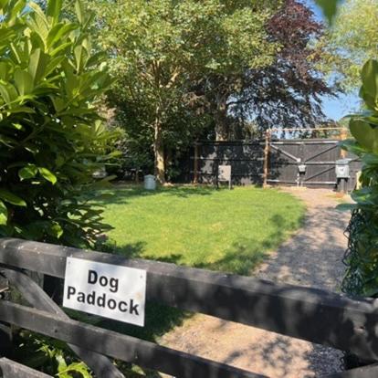 a dog paddock sign on a wooden fence at Hunston Mill Self Catering Dog Stay For Free in Chichester