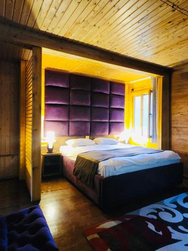 a bedroom with a large bed with a wooden ceiling at Resort Shareula in K'veda Ghvardia