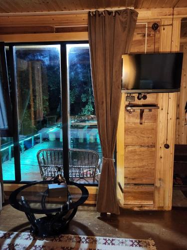 a room with a large window with a view of a pool at Resort Shareula in K'veda Ghvardia