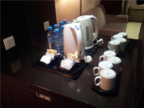 a counter with a coffee maker and cups on it at Raia Hotel & Convention Centre Alor Setar in Alor Setar