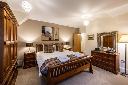 a bedroom with a large bed and a mirror at Moat House 8 Harris Apartment in Fort Augustus