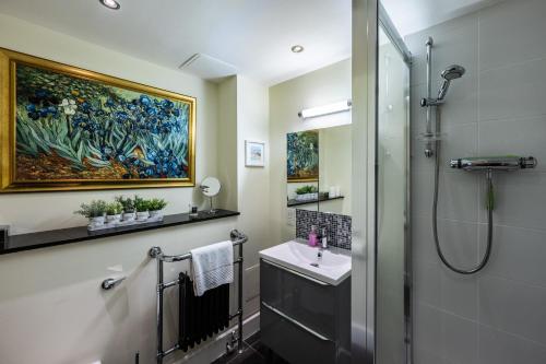a bathroom with a shower and a sink and a painting at Moat House 8 Harris Apartment in Fort Augustus