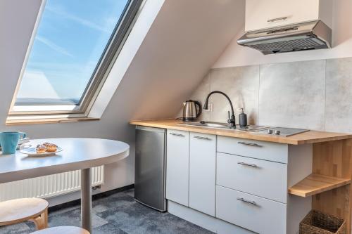 eine Küche mit einem Tisch und einem Fenster in der Unterkunft Pod Orlicą in Duszniki-Zdrój