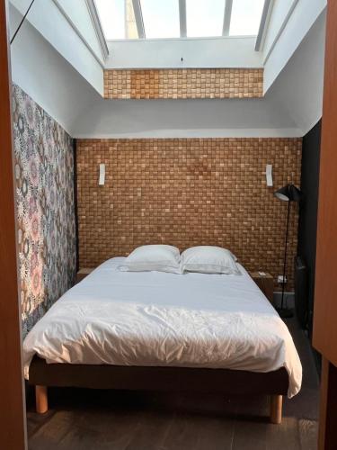 a bedroom with a bed with a brick wall at Le petit nid Aixois in Aix-en-Provence