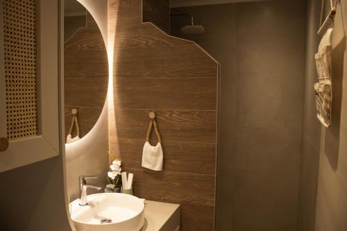 a bathroom with a sink and a toilet and a mirror at Chryso Boutique Guesthouse in Chrysoupolis