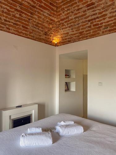 a bedroom with a bed with two towels on it at AviStar by Portus Alacer in Avis