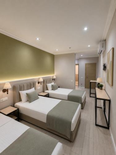 a hotel room with two beds and a table at Aqua Hotel in Bishkek