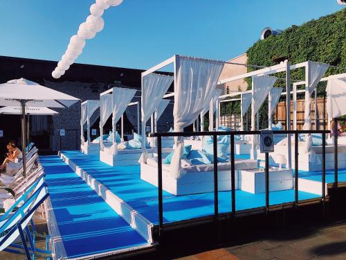 Eine Reihe von Betten in einem Pool mit Sonnenschirmen in der Unterkunft FlatDeCologne - Sommer in der Stadt- City Apartment Nähe DOM in Köln
