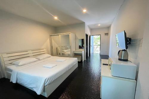 a bedroom with a white bed and a television at Fairtex Residence Pattaya in North Pattaya