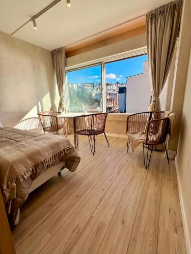 a bedroom with a bed and a table and chairs at Refugio del Sur in San Carlos de Bariloche