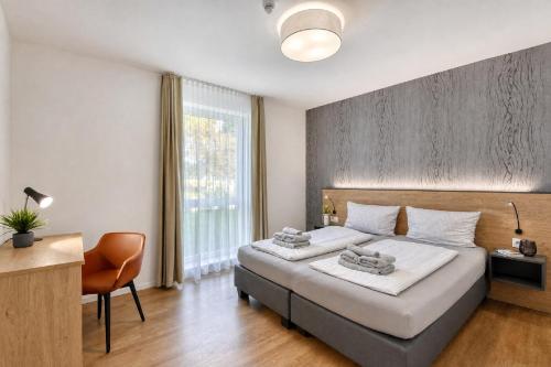 a bedroom with two beds and a desk and a window at Ferienwohnung Grünfink 04 im Wreecher Idyll Rügen by ruyastay in Putbus