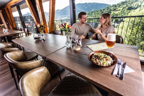 a man and woman sitting at a table in a restaurant at Resort Drevenice Terchova in Terchová