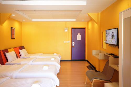 a row of beds in a room with a blue door at Room@Vipa in Bangkok