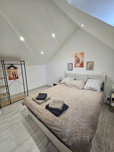 a bedroom with a large bed in a white room at Ma p'tite maison in Fumay
