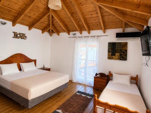 two beds in a room with wooden ceilings and a television at Bella Casa Lydia - Peaceful Retreat in Rhodes in Rhodes Town