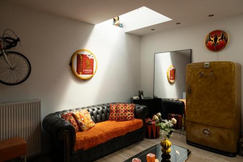 a living room with a leather couch and a mirror at Unique renovated chapel in Temse