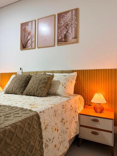 a bedroom with a bed and a table with a lamp at O mais charmoso do centro in Sinop